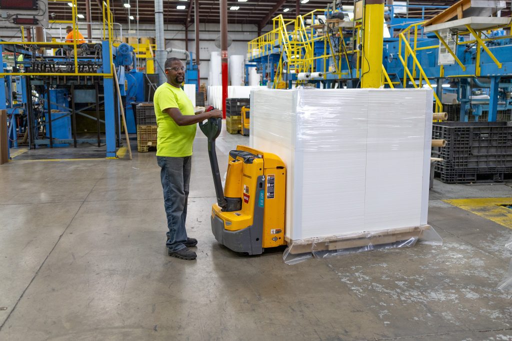 Man loading pallet in paper manufacturing facility