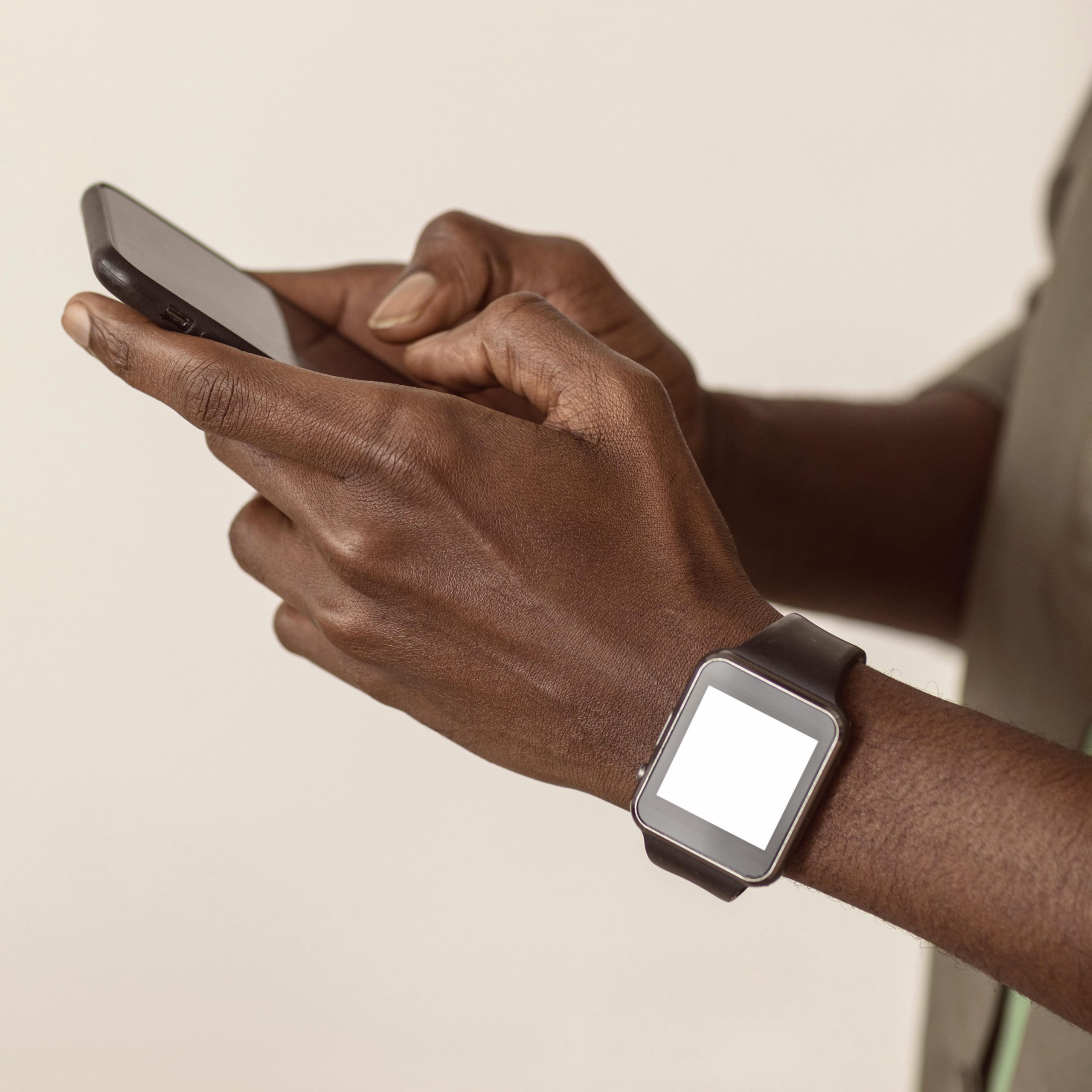 Man's hands close up holding smart phone, wearing smart watch